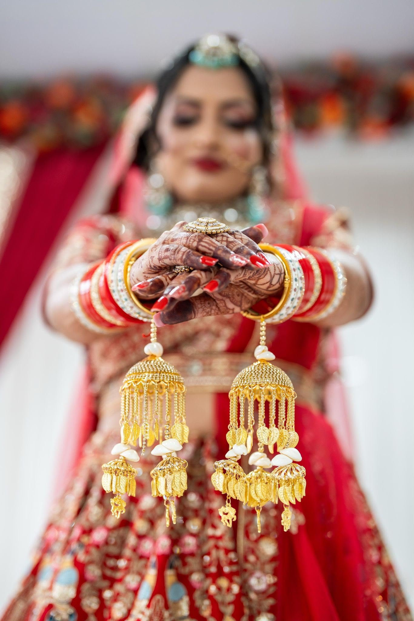 Bride holding out both hennaed hands with gold kalire